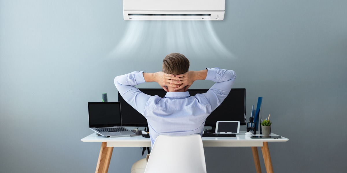 gentleman enjoying mini split air conditioning at desk