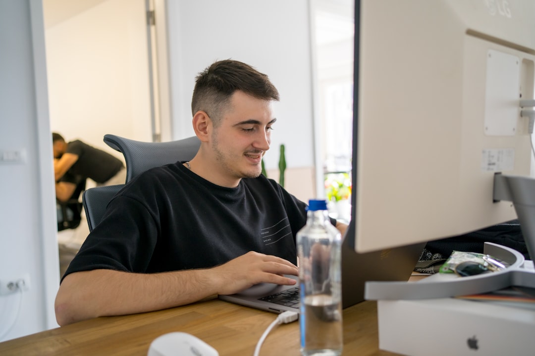 Professional and modern real estate agent sits in a bright, clean office, focused on their laptop, analyzing local market ...